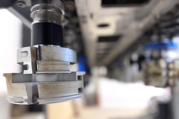 Nahaufnahme eines Maschinenfr&auml;swerkzeugs mit abgerundeten Kanten unter einer Maschinenstruktur.